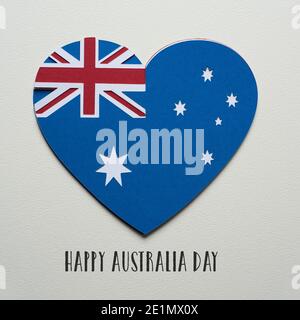 una bandiera australiana a forma di cuore, fatta con ritagli di carta di colori diversi, e il testo happy australia giorno su una testurizzata off-bianco b Foto Stock