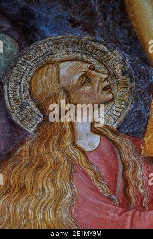 Dolore e angoscia sul volto di Maria Maddalena mentre Gesù muore sulla croce. Particolare dell'affresco frammentario del 1400s, attribuito all'artista rinascimentale Stefano d'Antonio di Vanni (1405-1483). Nella Chiesa di Sant’Agostino a Volterra, Toscana, Italia. Stefano d’Antonio di Vanni fu allievo del pittore e scultore fiorentino Bicci di Lorenzo (1373-1452). Foto Stock