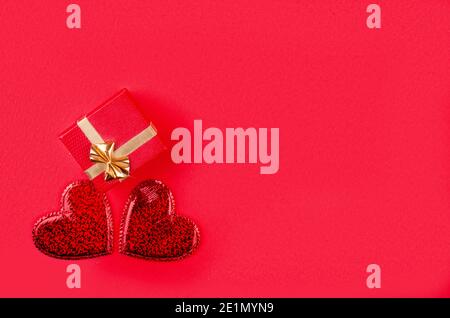 Confezione regalo con due tegole su sfondo rosso con spazio per la copia. Carta San Valentino. Festa della mamma, matrimonio, giorno della donna. Banner panoramico molto ampio sul retro Foto Stock