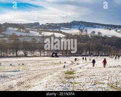 Due moduli grandi. Da Henry Moor, insieme a pecore e visitatori in uno Yorkshire Sculpture Park innevato. REGNO UNITO. Foto Stock