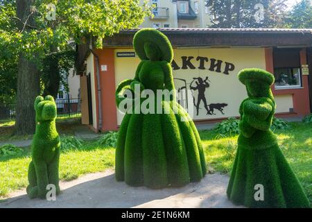 Pionersky, regione di Kaliningrad, Russia - Settembre, 2020: Figure di signora, ragazza e cane fatto di erba verde in strada. Topiario urbano. Foto Stock