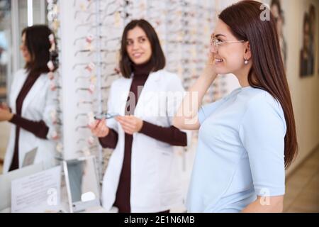 Cliente che ispeziona il suo aspetto in uno specchio da parete Foto Stock