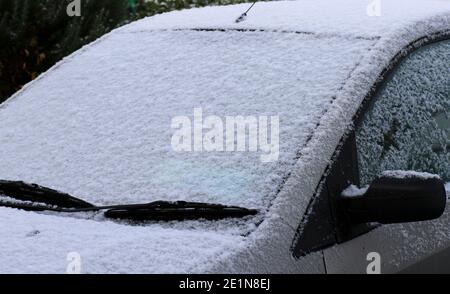 Neve sul parabrezza dell'auto dopo la notte nevicata durante l'inverno in Irlanda. Clima freddo e ghiacciato. Spazio di copia per il testo Foto Stock