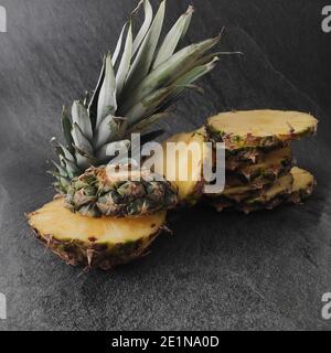 Ananas tagliato e affettato su sfondo scuro Foto Stock