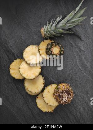 Ananas tagliato e affettato su sfondo scuro Foto Stock