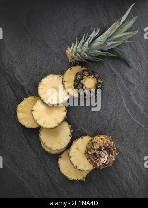 Ananas tagliato e affettato su sfondo scuro Foto Stock