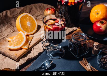 Splendida vista sul VIN brulé caldo con miele, frutta e spezie. Atmosfera fragrante delle vacanze invernali di Natale. Bicchiere con cannella e arancio Foto Stock