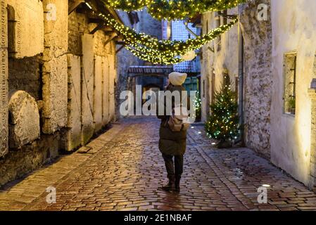 Donna turista guardando muro nel passaggio di Santa Caterina a Tallinn, Estonia Foto Stock