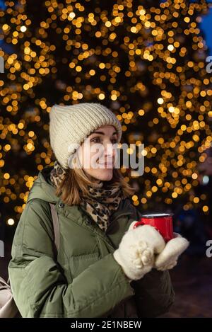 Donna che beve bevande calde o VIN brulé dalla propria tazza Sul mercato di Natale a Tallinn Foto Stock