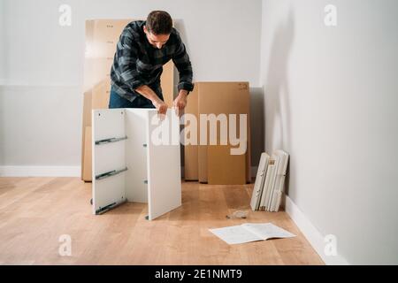 Ritratto di uomo che monta mobili. Fai da te mobili di montaggio. Foto Stock