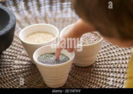 Semi vari e grani di salute disposti in ciotole vari semi sani disposti in ciotole che includono grani antichi come semi di lino, bianco e br Foto Stock
