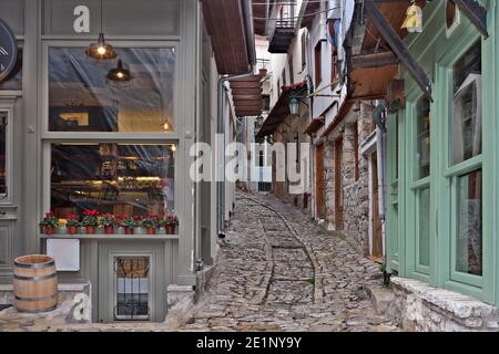 Vicolo tradizionale al villaggio di Dimitsana, un antico e pittoresco villaggio in Grecia, con vecchie case ben conservate e strade lastricate di pietra. Foto Stock