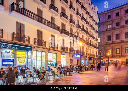 La gente gode la serata su un patio ristorante nel centro di Madrid, Spagna Foto Stock