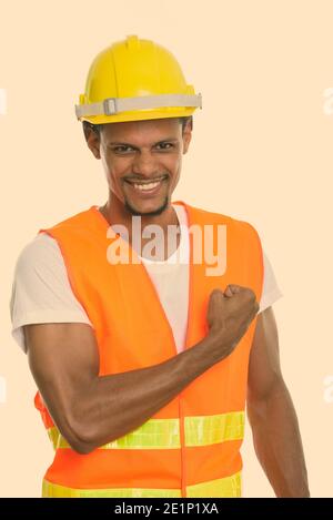 I giovani africani felice l'uomo lavoratore edile sorridente con la mano sul petto Foto Stock