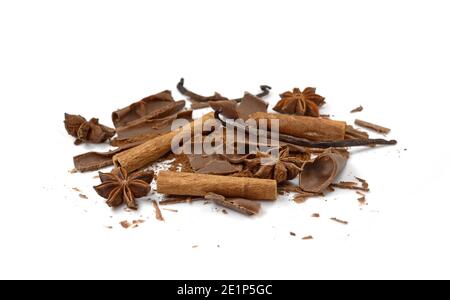 Stecche di cannella, stella di anice, rotoli di cioccolato e polvere di cacao isolati su sfondo bianco primo piano. Bastoncini di cannella speziata e stella di anice. Foto Stock