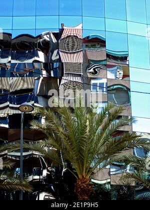 Città di Alicante, Spagna. Riflesso distorto di un edificio nella facciata in vetro riflettente di un altro edificio sul lato opposto della strada. Foto Stock