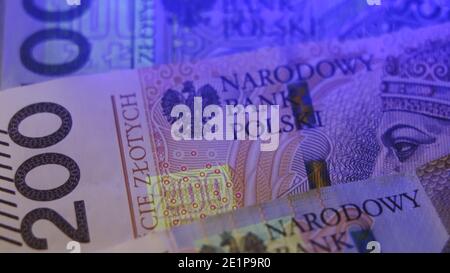 Varsavia, Polonia 01.01.2021 zloty polacco sotto la lampada UV. Test del denaro della carta per il concetto di contraffazione. Primo piano estremo delle caratteristiche di sicurezza del denaro. Foto di alta qualità Foto Stock