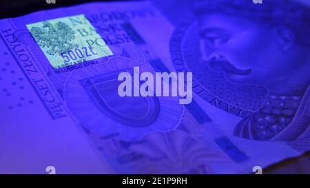Varsavia, Polonia 01.01.2021 zloty polacco sotto la lampada UV. Test del denaro della carta per il concetto di contraffazione. Primo piano estremo delle caratteristiche di sicurezza del denaro. Foto di alta qualità Foto Stock
