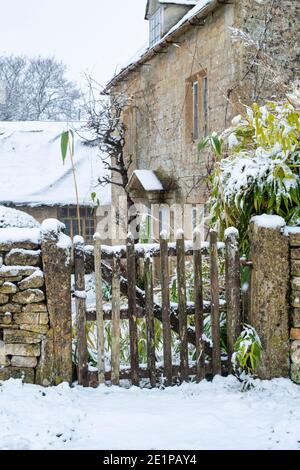 Cotswold cottage in pietra e fienile nella neve di dicembre. Taynton, Cotswolds, Oxfordshire, Inghilterra Foto Stock