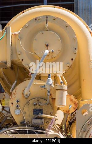 Un'immagine verticale anonima, in primo piano di arrugginimento disusato verniciato giallo, macchinari pesanti Foto Stock