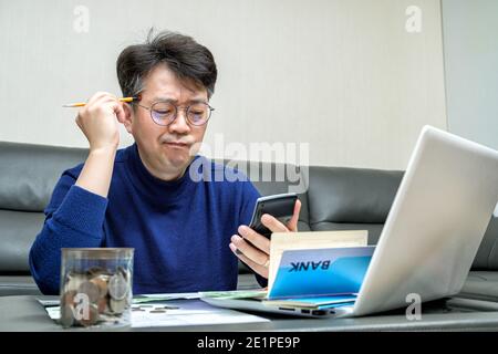 L'uomo asiatico di mezza età si prepara alla dichiarazione dei redditi. Foto Stock