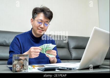 L'uomo asiatico di mezza età si prepara alla dichiarazione dei redditi. Foto Stock