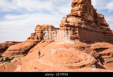 Una donna che fa escursioni nel distretto di Needles del Canyonlands National Park, Utah, USA. Foto Stock