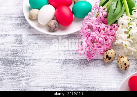 Uova di Pasqua, giacinto rosa e bianco su sfondo ligneo. Concetto di Pasqua. Vista dall'alto. Spazio di copia - immagine Foto Stock