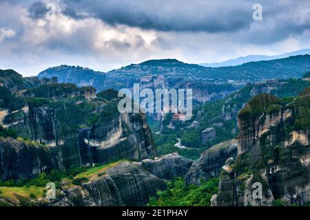 Vista su colonne di rocce sedimentarie nella famosa valle di Meteora in giornata. Monastero di Roussanou e di Varlaam, Grecia, patrimonio mondiale dell'UNESCO Foto Stock