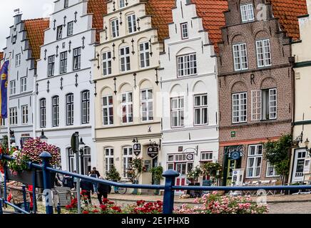 FRIEDRICHSTADT, GERMANIA-13 LUGLIO 2019: Mercato con una fila di case storiche a timpano sulla piazza del mercato di Friedrichstadt, Germania Foto Stock