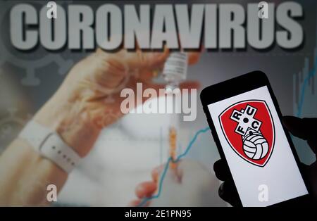 Il logo Rotherham United Football Club visualizzato su Telefono cellulare con un'illustrazione Coronavirus su un monitor in lo sfondo Foto Stock