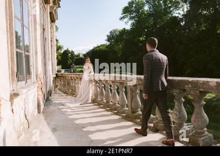 Lo sposo va alla sposa sulla terrazza del palazzo. Ritratto della sposa e dello sposo Foto Stock