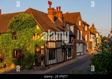 Il Leather Bottle inn e gli edifici sulla High St Cobham al tramonto Foto Stock