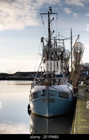 La barca di salvataggio e la barca da pesca sono ormeggiate presso la banchina nel porto di Lemmer, Paesi Bassi. Concentrarsi sull'arco della nave Foto Stock