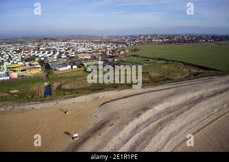 Selsey Beach con il famoso parco caravan per le vacanze sullo sfondo a Medmery. Foto Stock