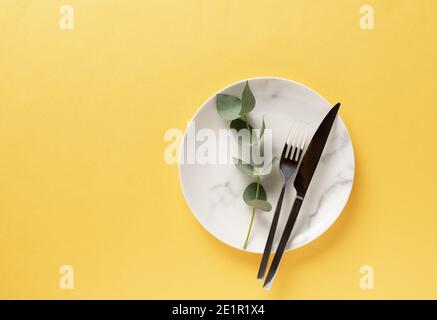 piastra in marmo di ceramica con posate. Giallo luminoso e grigio estremo Foto Stock