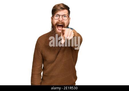 Giovane irlandese rosso uomo che indossa abiti casual e occhiali puntando dispiaciuto e frustrato alla macchina fotografica, arrabbiato e furioso con voi Foto Stock