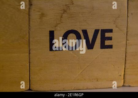 parola amore scritto su un cubo di legno in nero Foto Stock