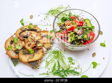 Sandwich con funghi fritti, basilico, semi di zucca e micrograni - piantine di ravanello e cipolla e insalata di pomodoro e cetrioli, servita con sesamo vedere Foto Stock