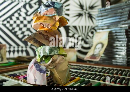 Banconote del cono monetario venezuelano su strumenti di disegno, in un contesto astratto di figure geometriche in nero e in banca Foto Stock