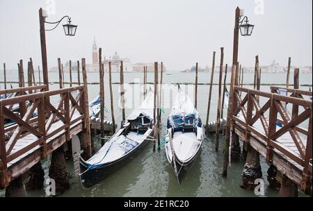 Gondole e pontoni rivestiti di neve, Venezia Italia Foto Stock