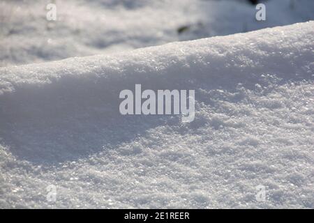 neve in luce solare invernale con effetti bokeh e riflessi di luce vista ravvicinata Foto Stock