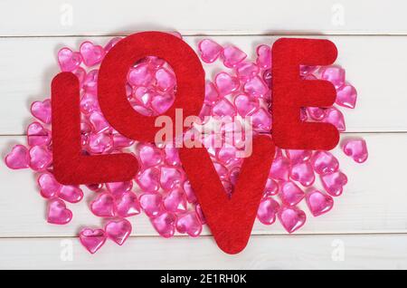 San Valentino sfondo, parola amore su uno sfondo di cuori rosa su uno sfondo di legno bianco Foto Stock