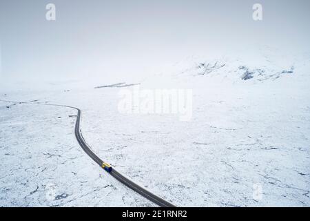 Vista aerea della strada A82 attraverso Rannoch Moor e Black Montare coperto di neve durante l'inverno Foto Stock