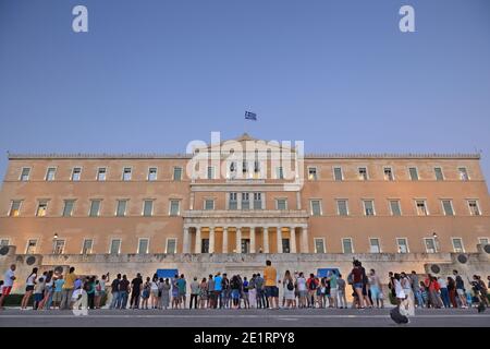 Turisti di fronte al Parlamento greco, in piazza Syntagma, guardando il cambio delle guardie presidenziali, ad Atene, Grecia, Europa. Foto Stock