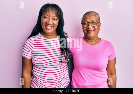 Famiglia ispanica di madre e figlia che abbracciano insieme con amore aspetto positivo e felice in piedi e sorridente con un fiducioso sorridi mostrando i denti Foto Stock