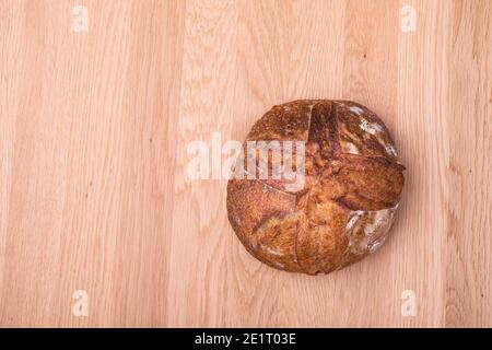 Pane tondeggiante di pasta fresca su tavolo di legno Foto Stock