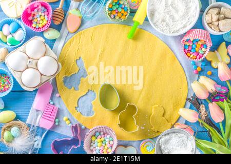 Famiglia fatta in casa vacanza pasta di Pasqua concetto. Pasqua cottura sfondo con la mamma e la figlia bambino mani, piano vista dall'alto. Con l'impasto, si forma la cupcake Foto Stock