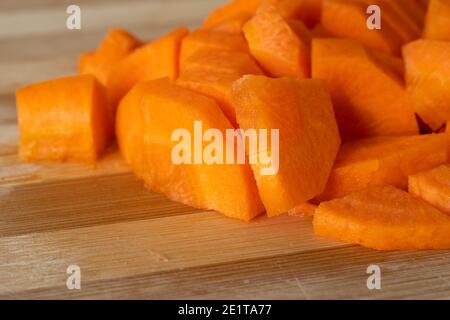 Un mucchio di carote fresche tagliate su tavola legnosa. Cibo Foto Stock