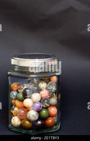 Collezione di palline di marmo in pietra in un vaso di vetro Foto Stock